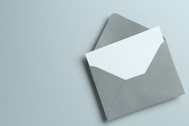 Photo of Blank invitation card and envelope on grey background, top view. Space for text
