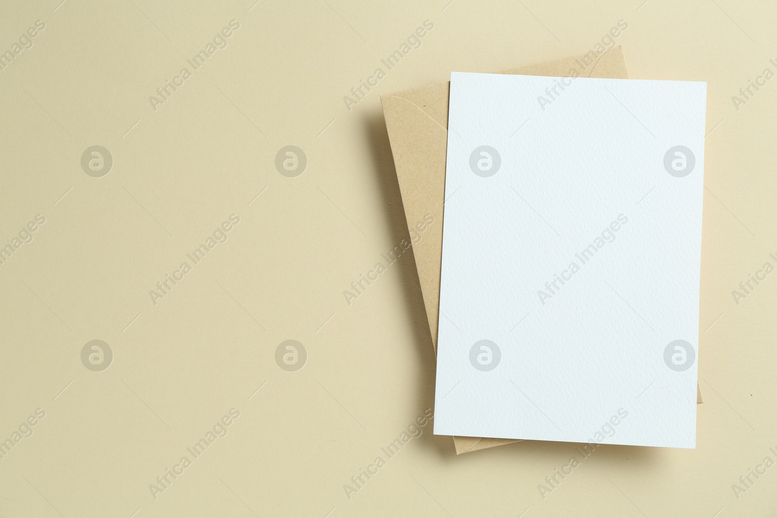 Blank invitation card and envelope on beige background, top view. Space for design Photo of Blank invitation card and envelope on beige background, top view. Space for design