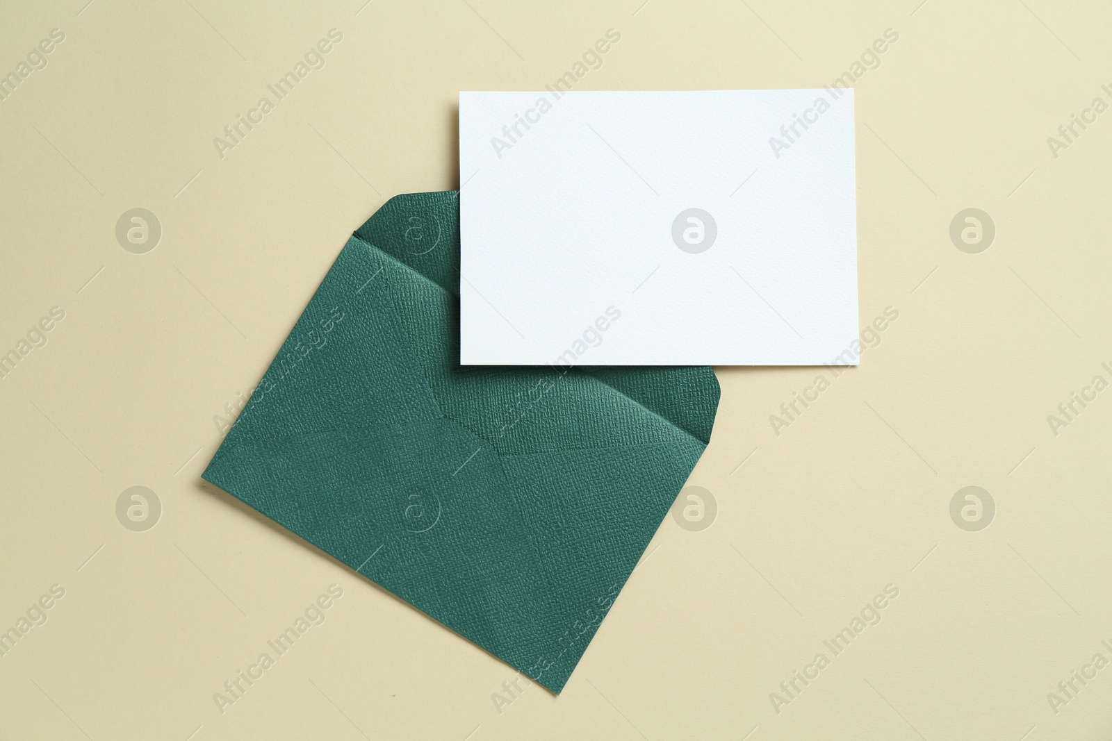 Blank invitation card and envelope on beige background, flat lay. Space for design Photo of Blank invitation card and envelope on beige background, flat lay. Space for design