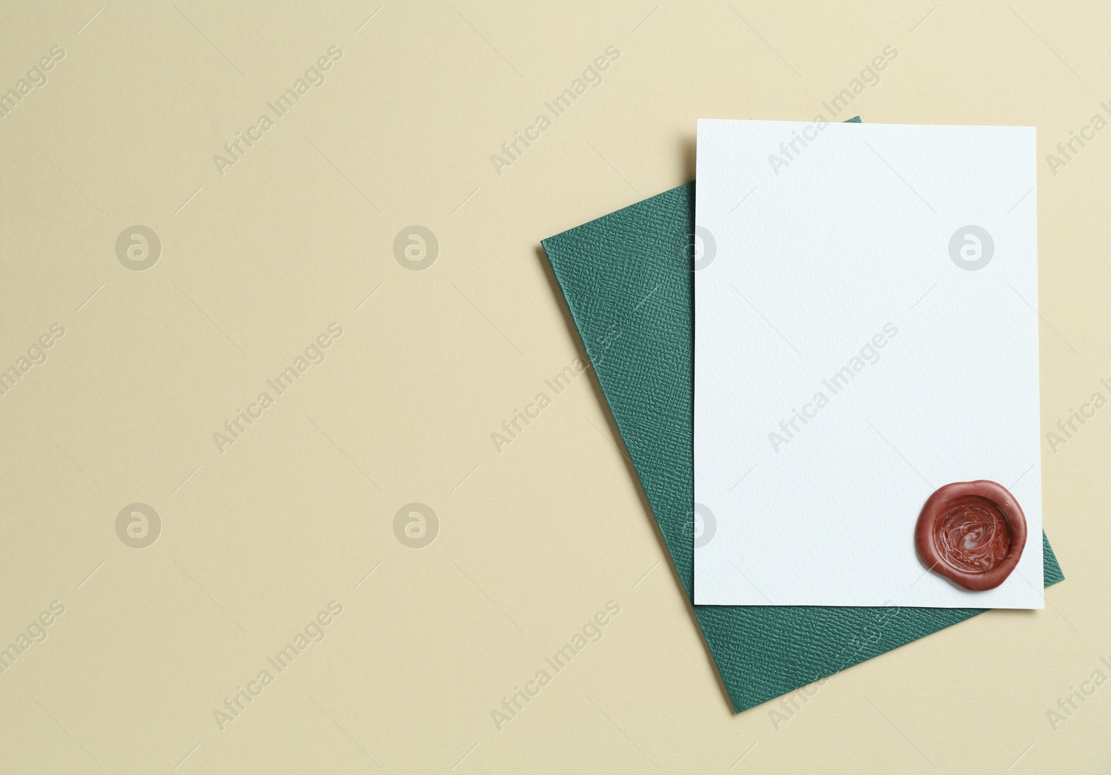 Blank invitation card with wax seal and envelope on beige background, top view. Space for design Photo of Blank invitation card with wax seal and envelope on beige background, top view. Space for design