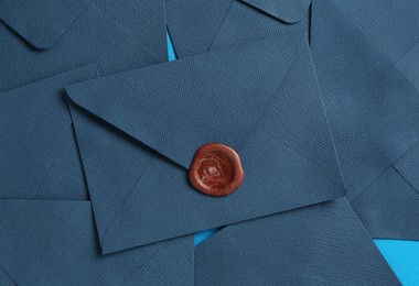 Photo of Beautiful invitation envelopes on light blue background, flat lay