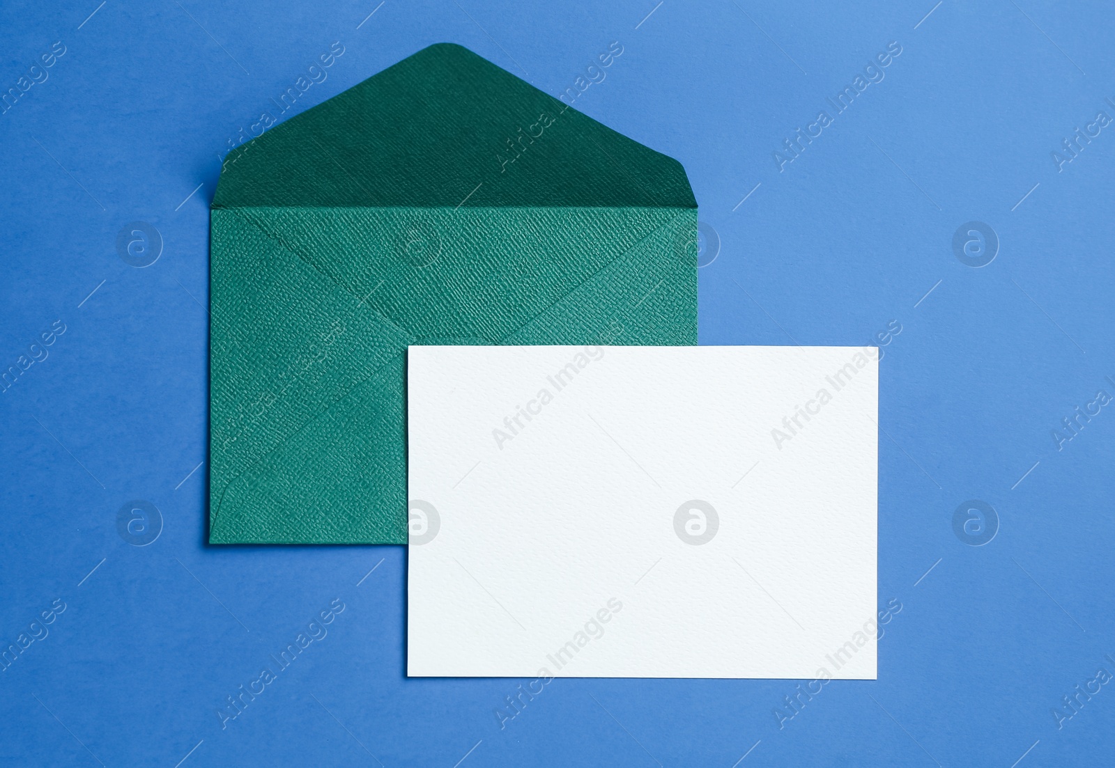 Blank invitation card and envelope on blue background, top view. Space for design Photo of Blank invitation card and envelope on blue background, top view. Space for design