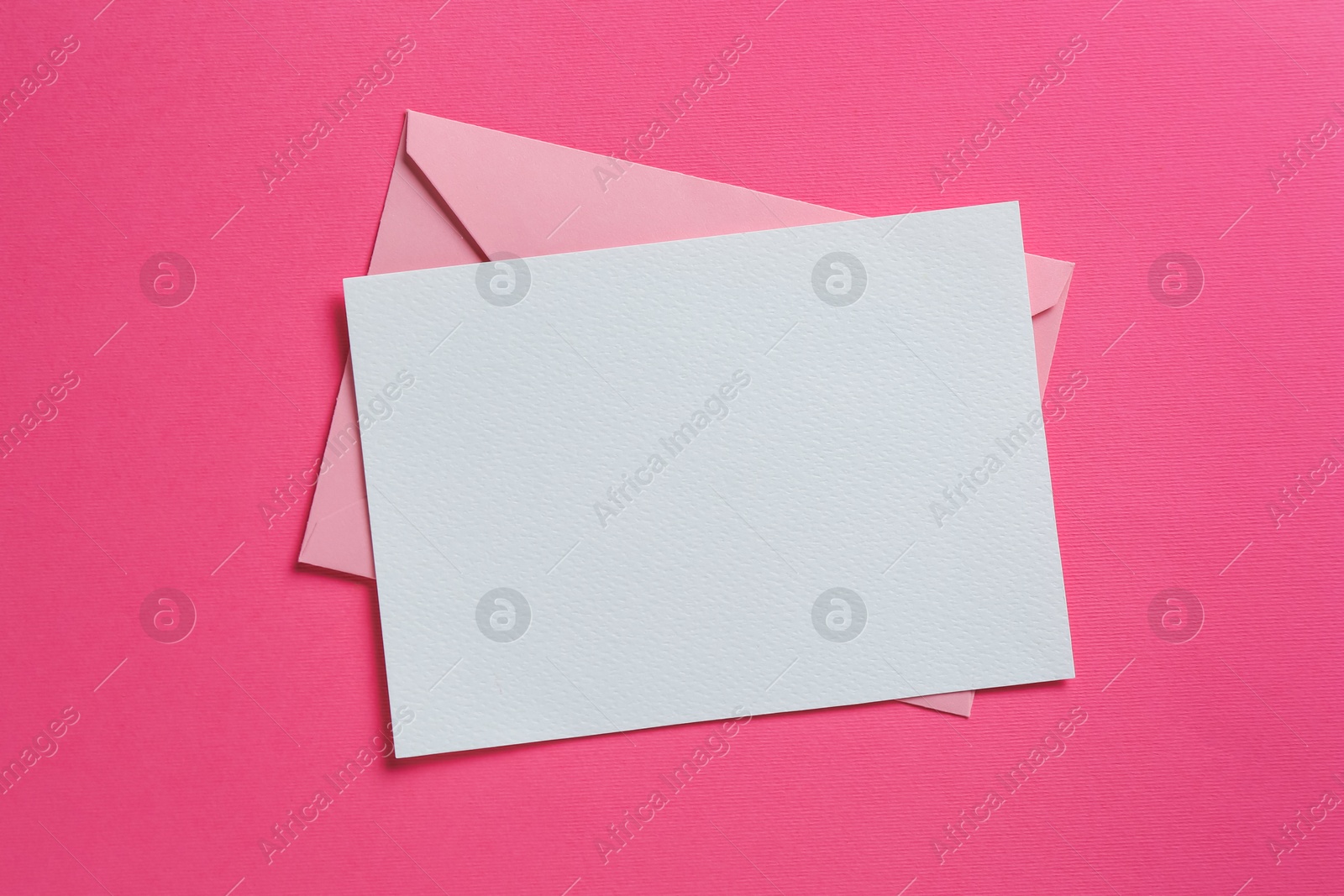 Blank invitation card and envelope on pink background, top view. Space for design Photo of Blank invitation card and envelope on pink background, top view. Space for design