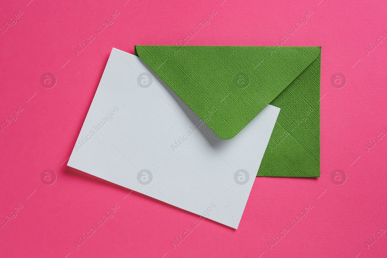 Blank invitation card and envelope on pink background, top view. Space for design Photo of Blank invitation card and envelope on pink background, top view. Space for design