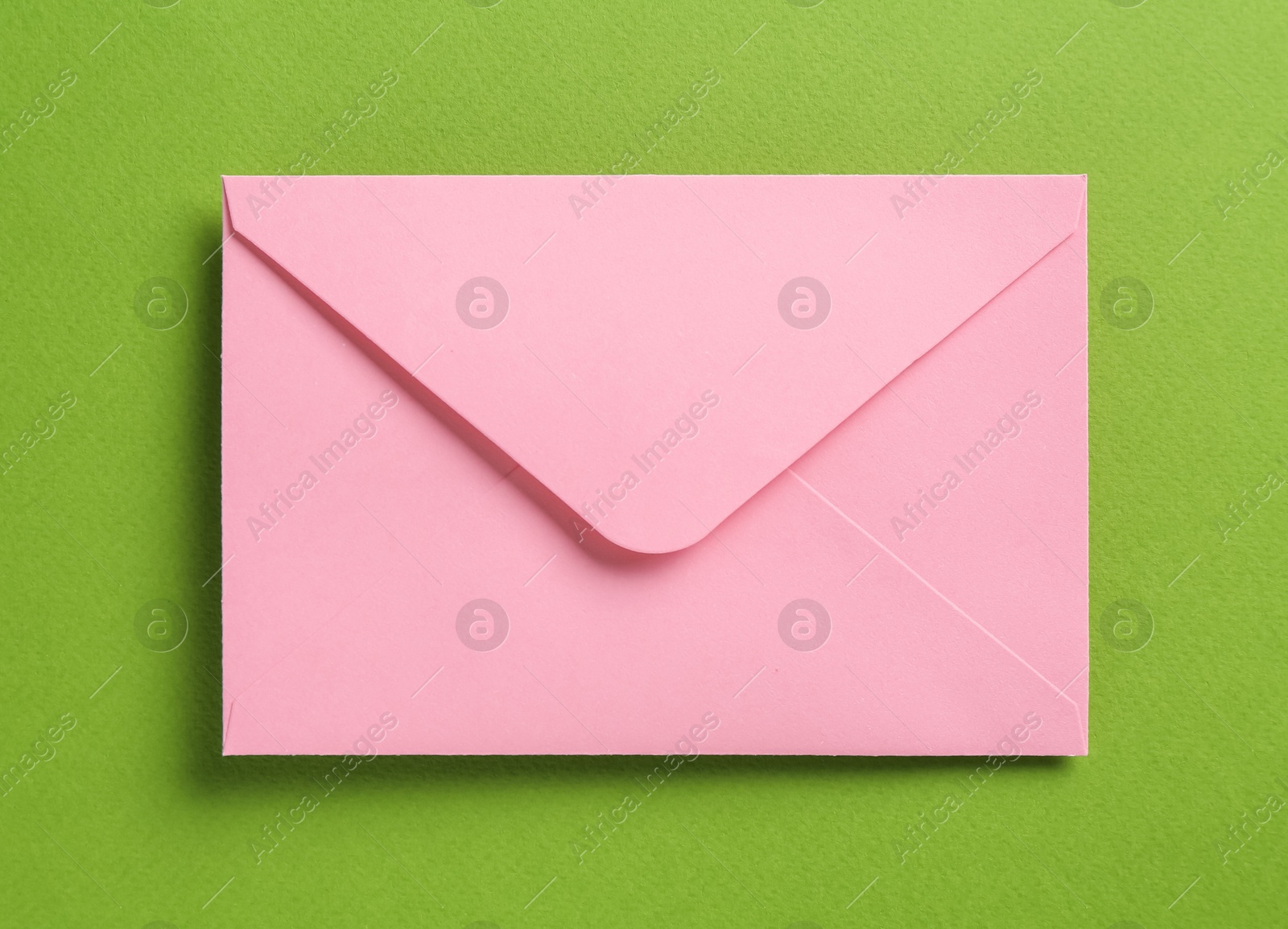 Beautiful invitation envelope on green background, top view Photo of Beautiful invitation envelope on green background, top view