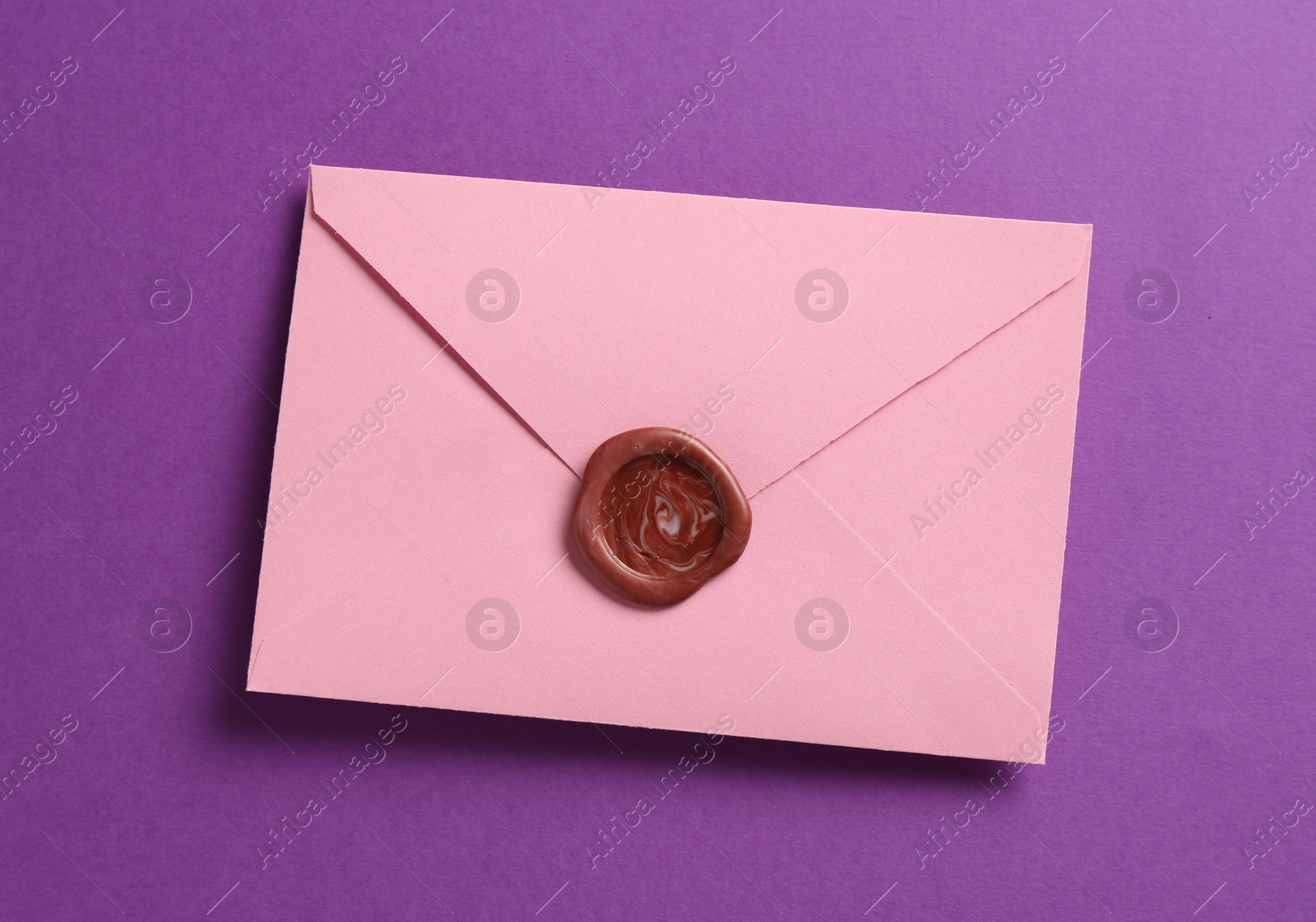 Beautiful invitation envelope with wax seal on purple background, top view Photo of Beautiful invitation envelope with wax seal on purple background, top view