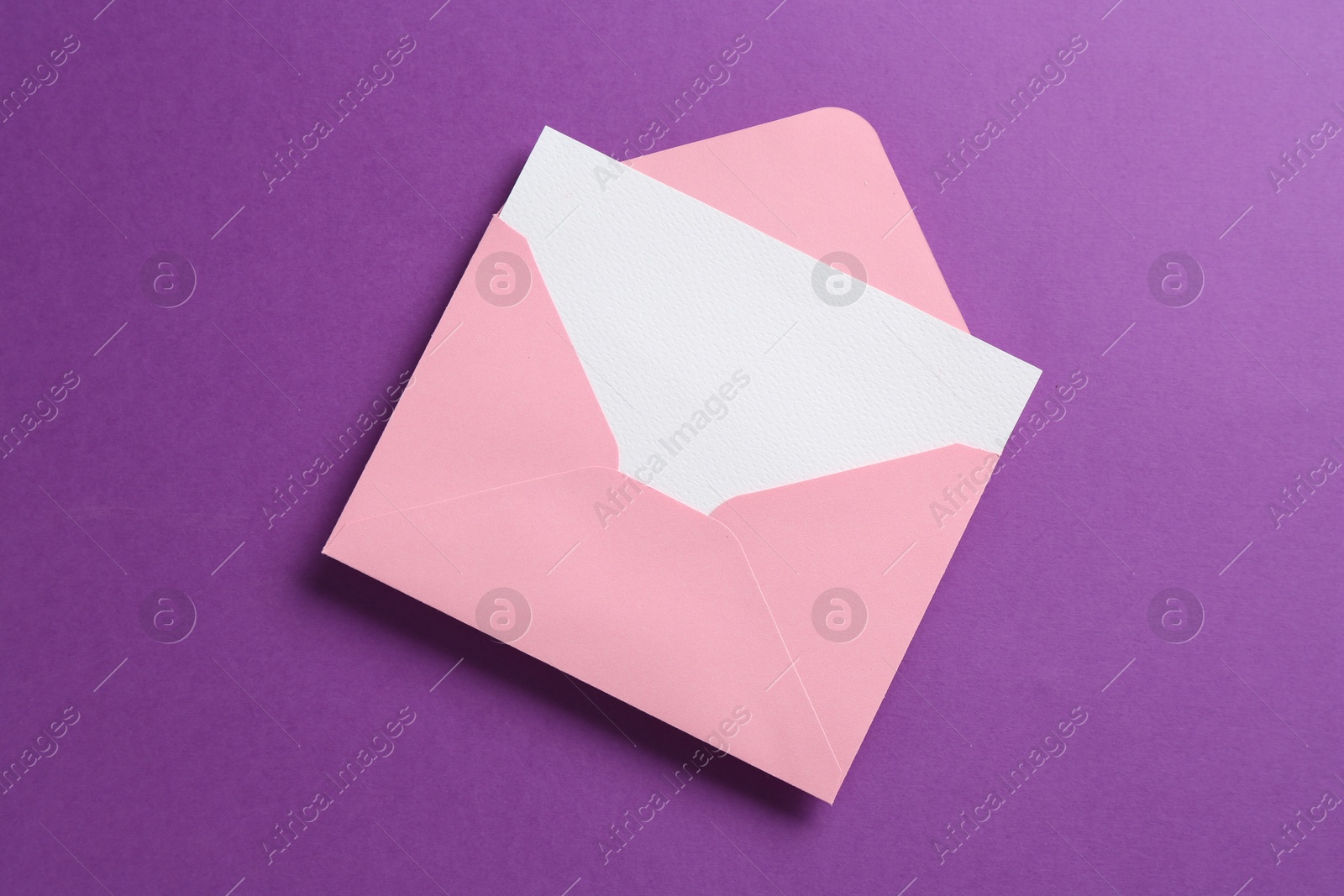 Blank invitation card and envelope on purple background, top view Photo of Blank invitation card and envelope on purple background, top view