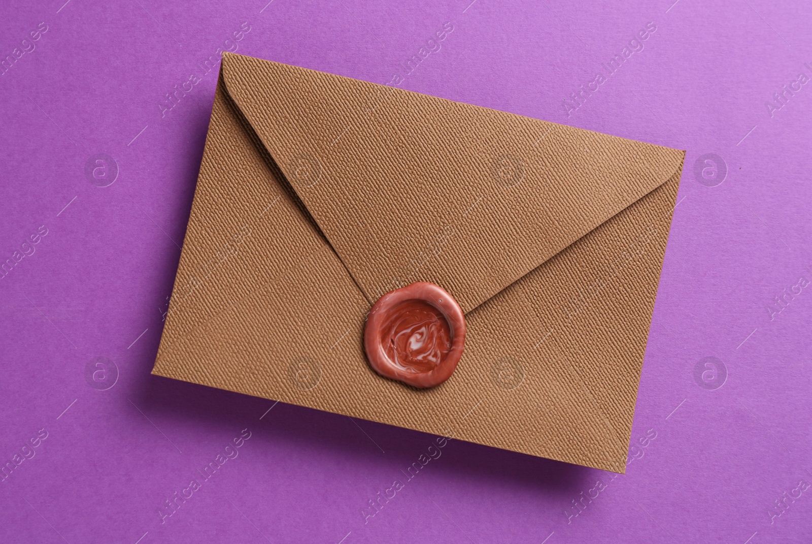Beautiful invitation envelope with wax seal on purple background, top view Photo of Beautiful invitation envelope with wax seal on purple background, top view