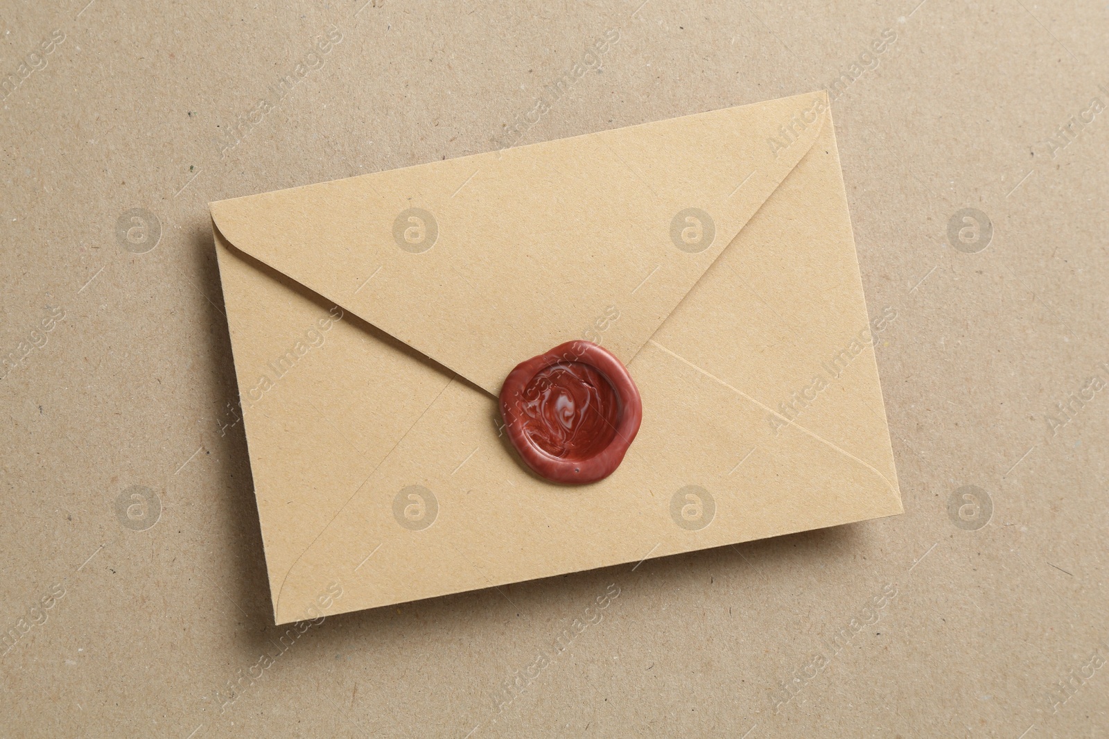Beautiful invitation envelope with wax seal on carton, top view Photo of Beautiful invitation envelope with wax seal on carton, top view