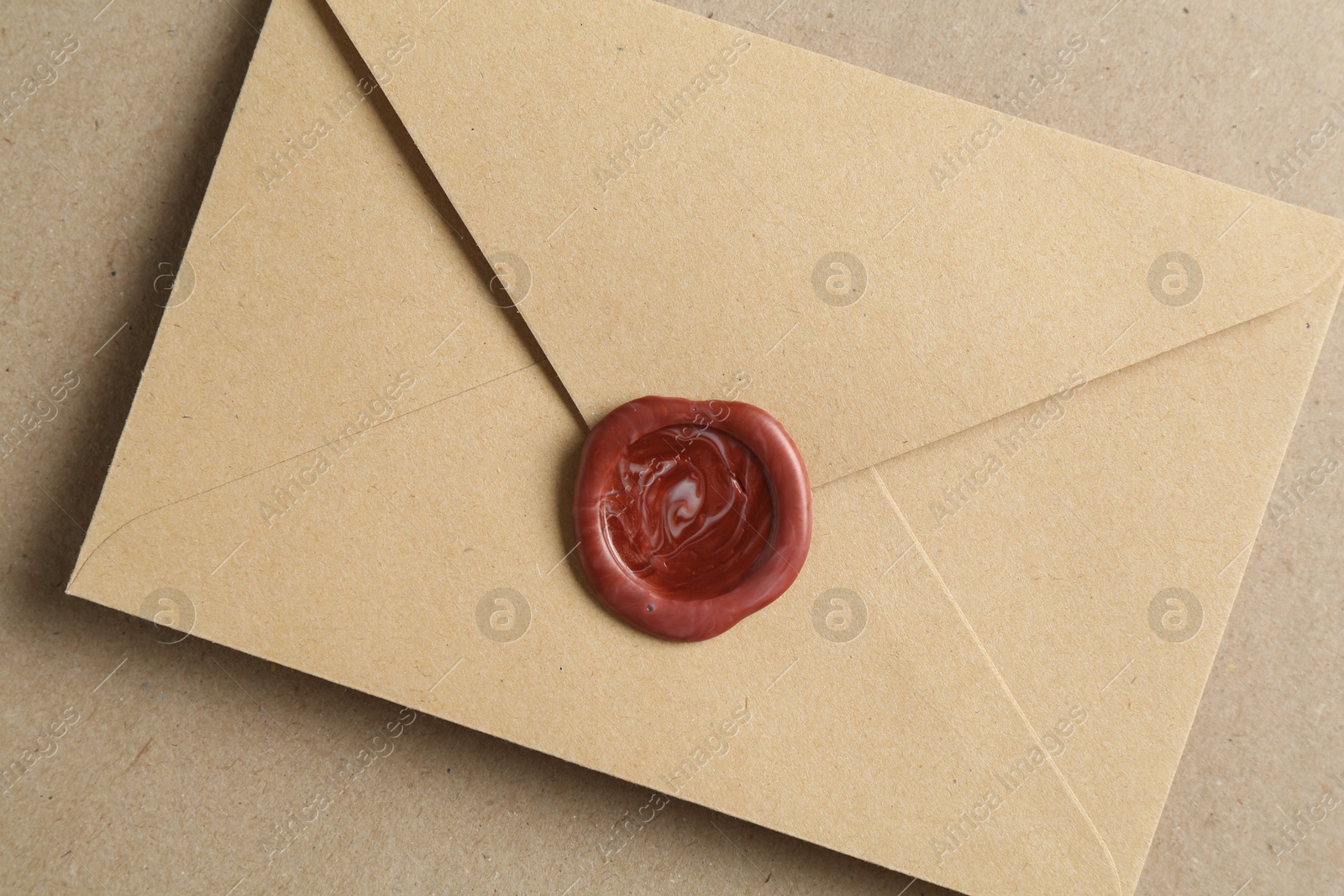 Beautiful invitation envelope with wax seal on carton, top view Photo of Beautiful invitation envelope with wax seal on carton, top view