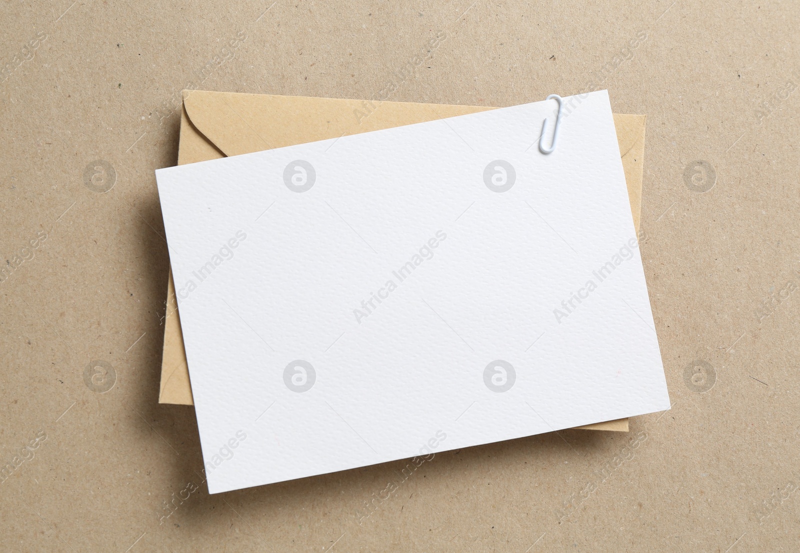 Blank invitation card and envelope on carton, top view. Space for design Photo of Blank invitation card and envelope on carton, top view. Space for design