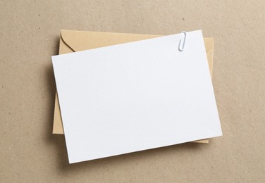 Photo of Blank invitation card and envelope on carton, top view. Space for design