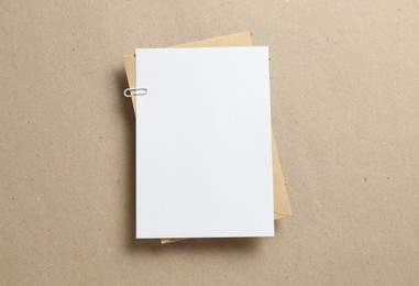 Photo of Blank invitation card and envelope on carton, top view. Space for design