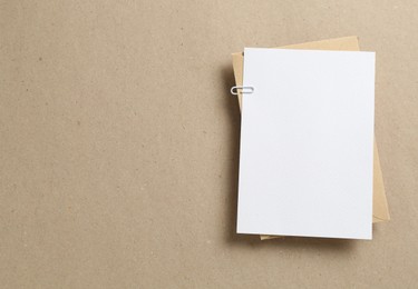 Photo of Blank invitation card and envelope on carton, top view. Space for design