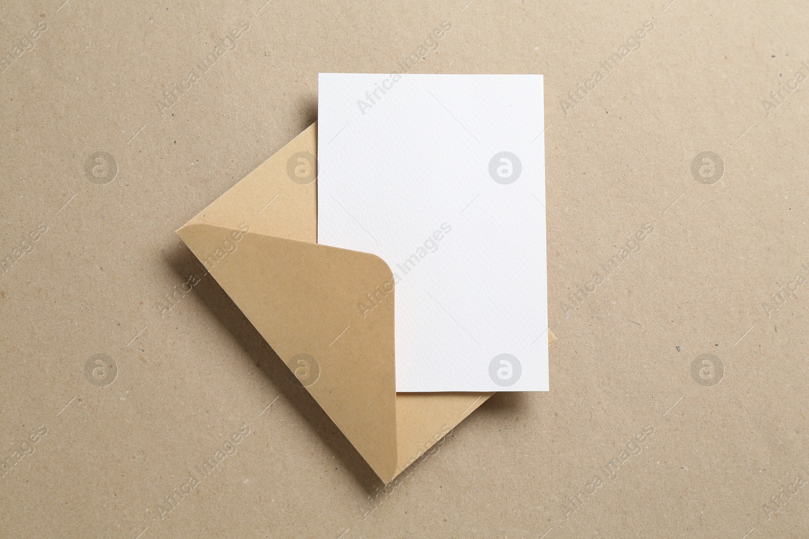 Blank invitation card and envelope on carton, top view. Space for design Photo of Blank invitation card and envelope on carton, top view. Space for design