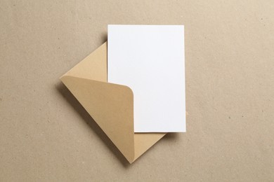 Photo of Blank invitation card and envelope on carton, top view. Space for design
