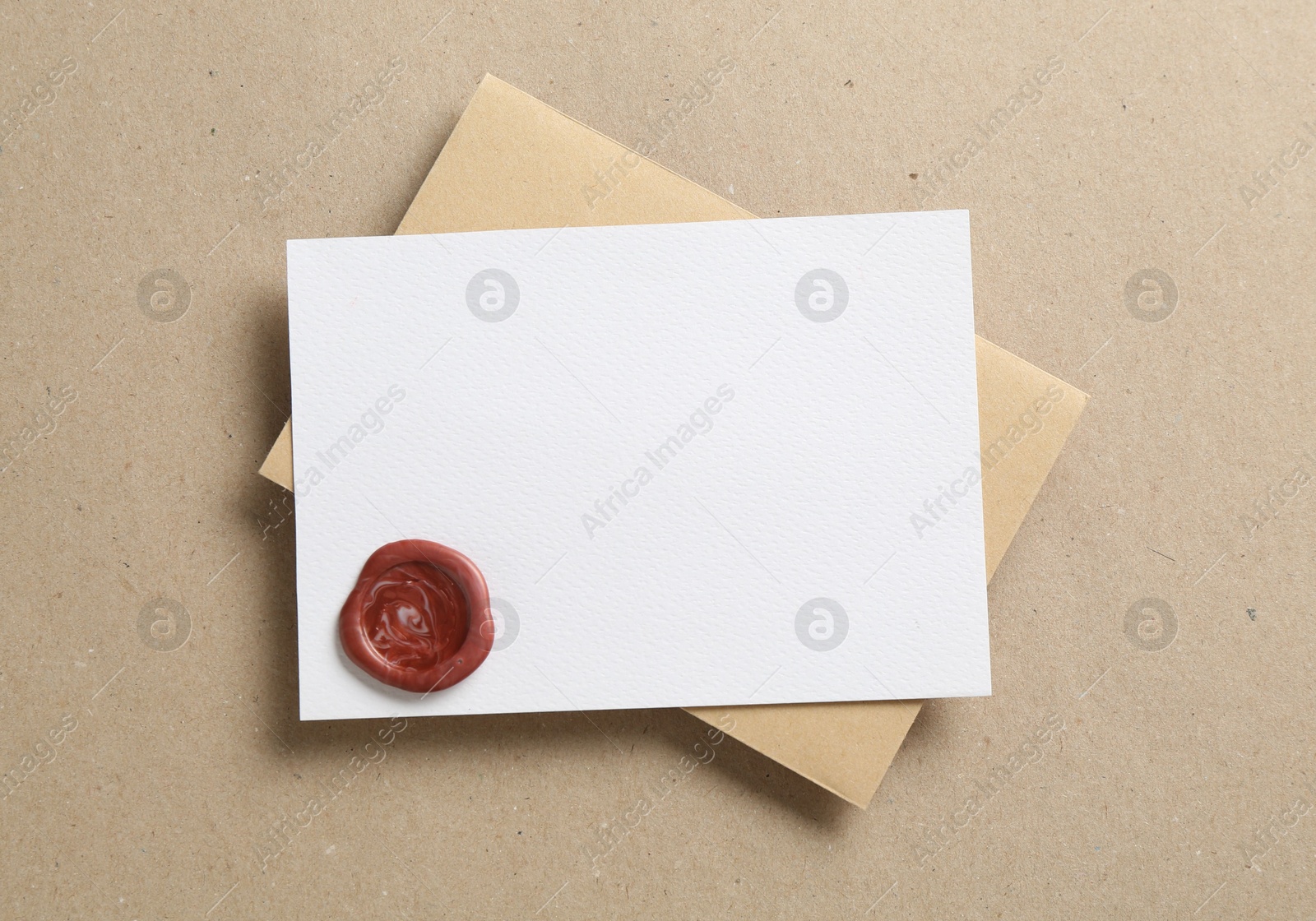 Blank invitation card with wax seal and envelope on carton, top view. Space for design Photo of Blank invitation card with wax seal and envelope on carton, top view. Space for design