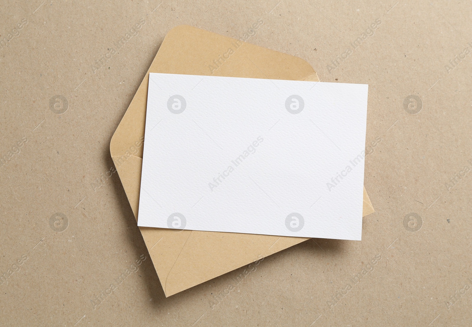 Blank invitation card and envelope on carton, top view. Space for design Photo of Blank invitation card and envelope on carton, top view. Space for design