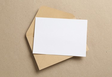 Photo of Blank invitation card and envelope on carton, top view. Space for design