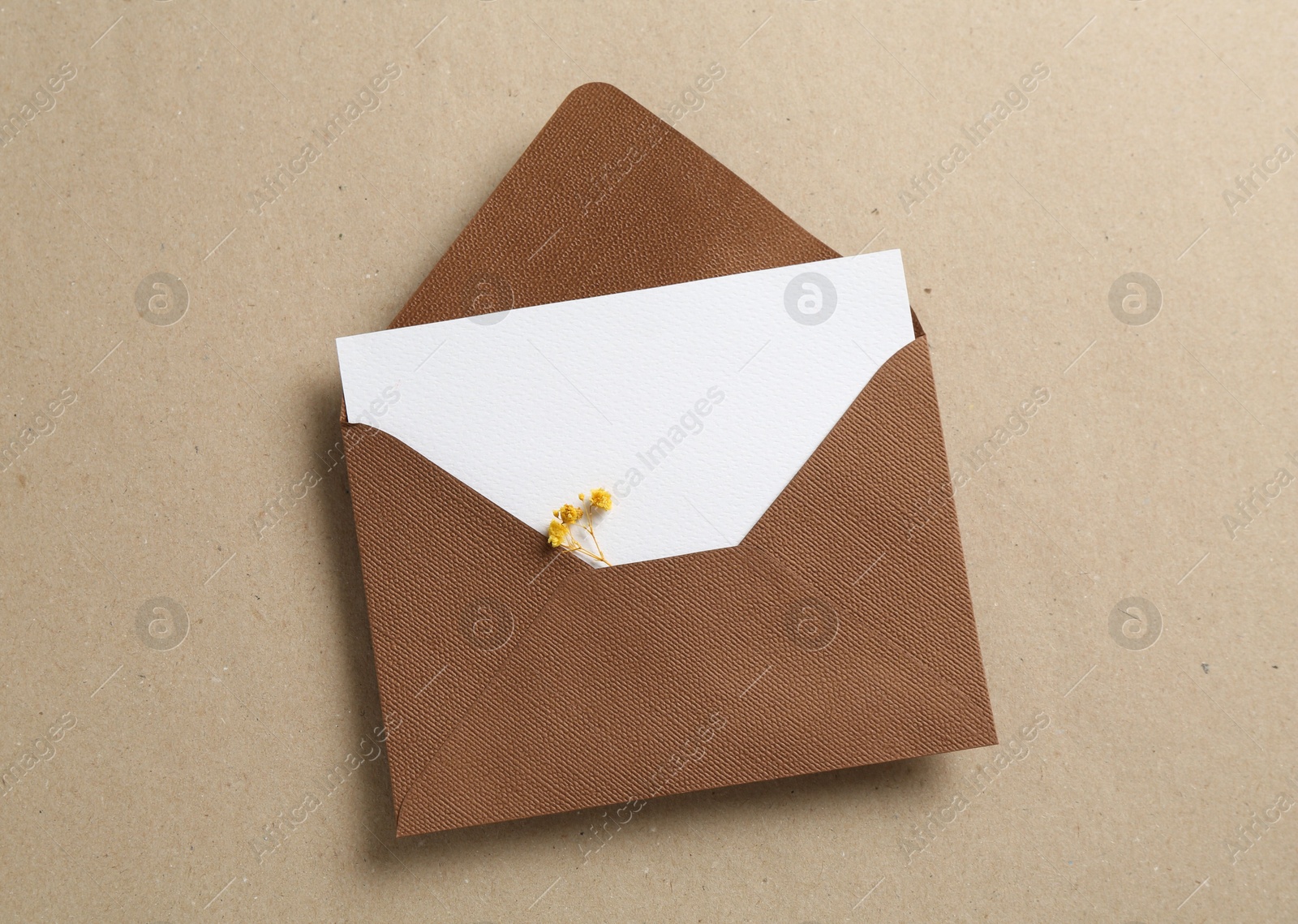 Blank invitation card with flowers and envelope on carton, top view Photo of Blank invitation card with flowers and envelope on carton, top view