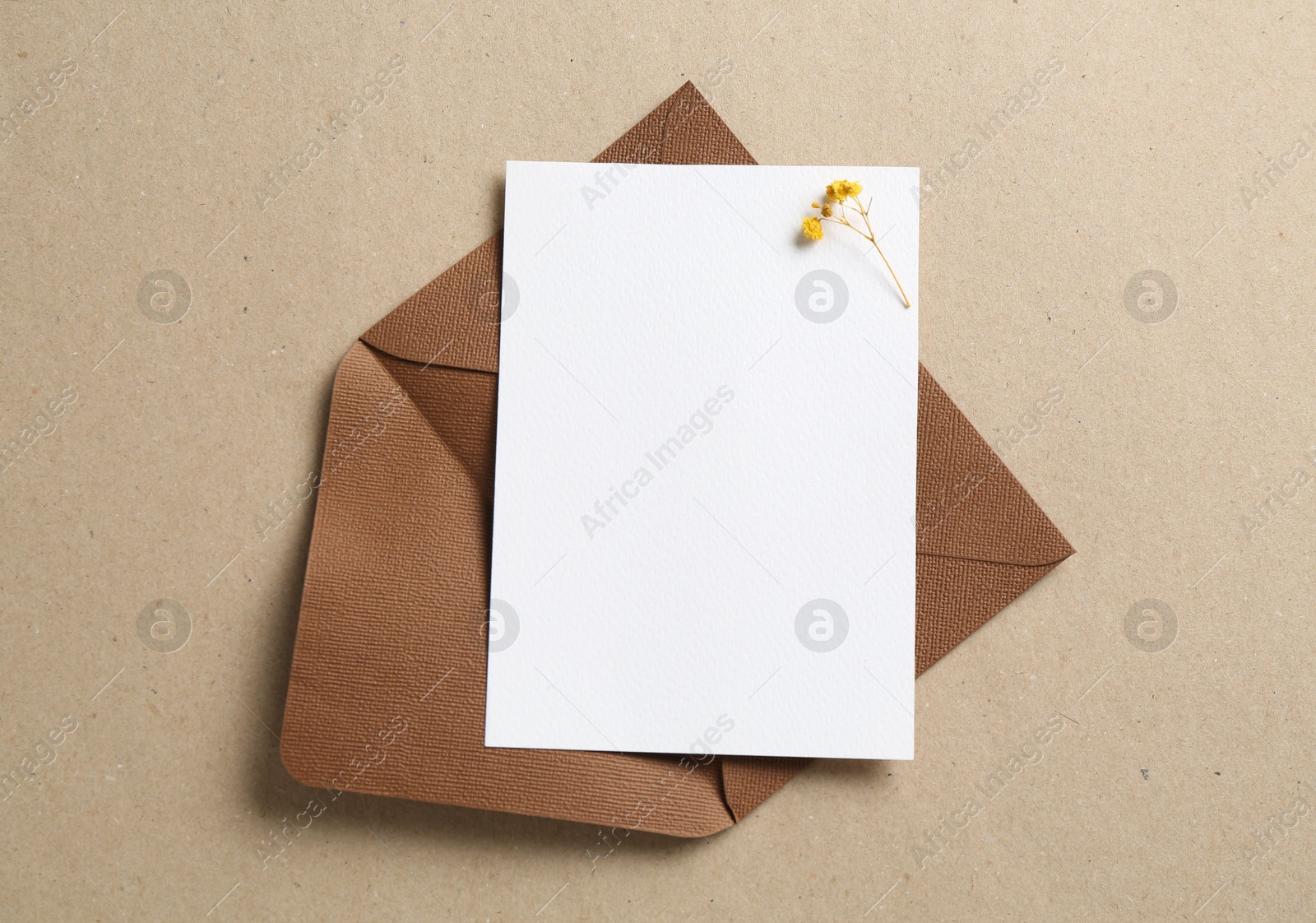 Blank invitation card and envelope on carton, top view. Space for design Photo of Blank invitation card and envelope on carton, top view. Space for design