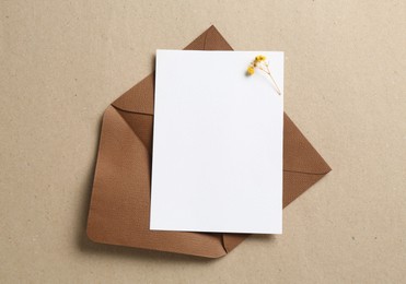 Photo of Blank invitation card and envelope on carton, top view. Space for design