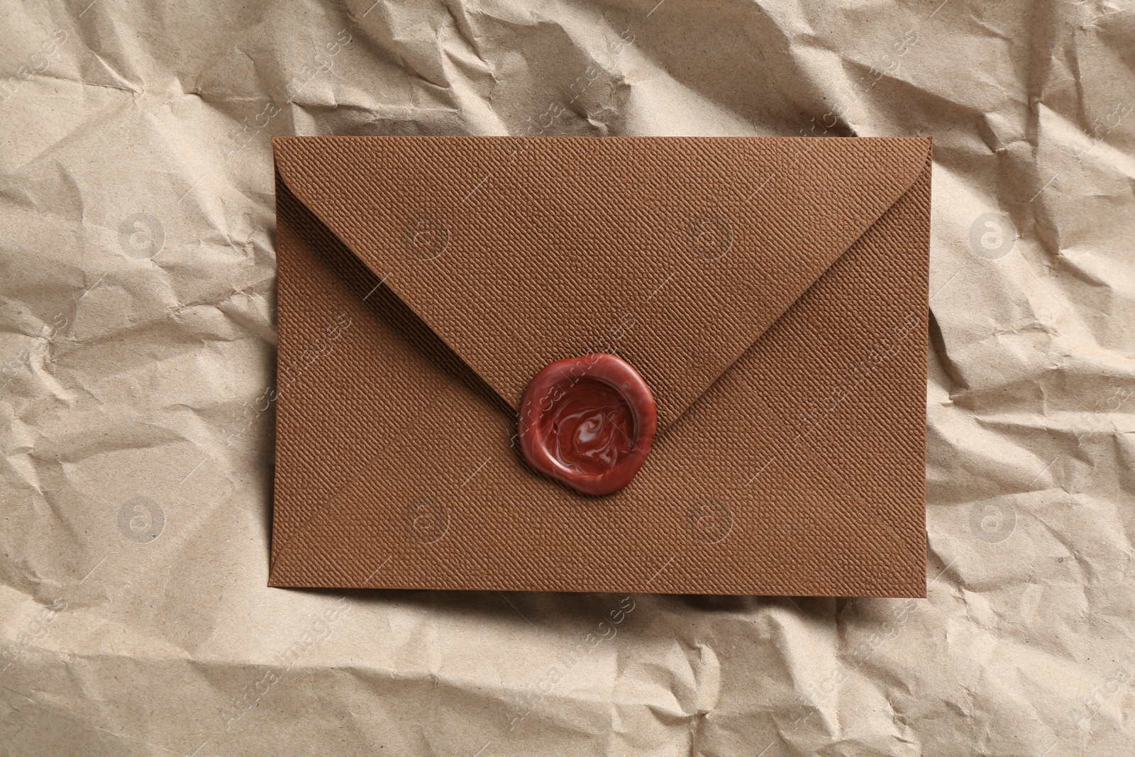 Beautiful invitation envelope with wax seal on parchment paper, top view Photo of Beautiful invitation envelope with wax seal on parchment paper, top view