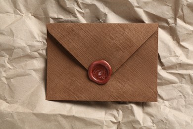 Photo of Beautiful invitation envelope with wax seal on parchment paper, top view