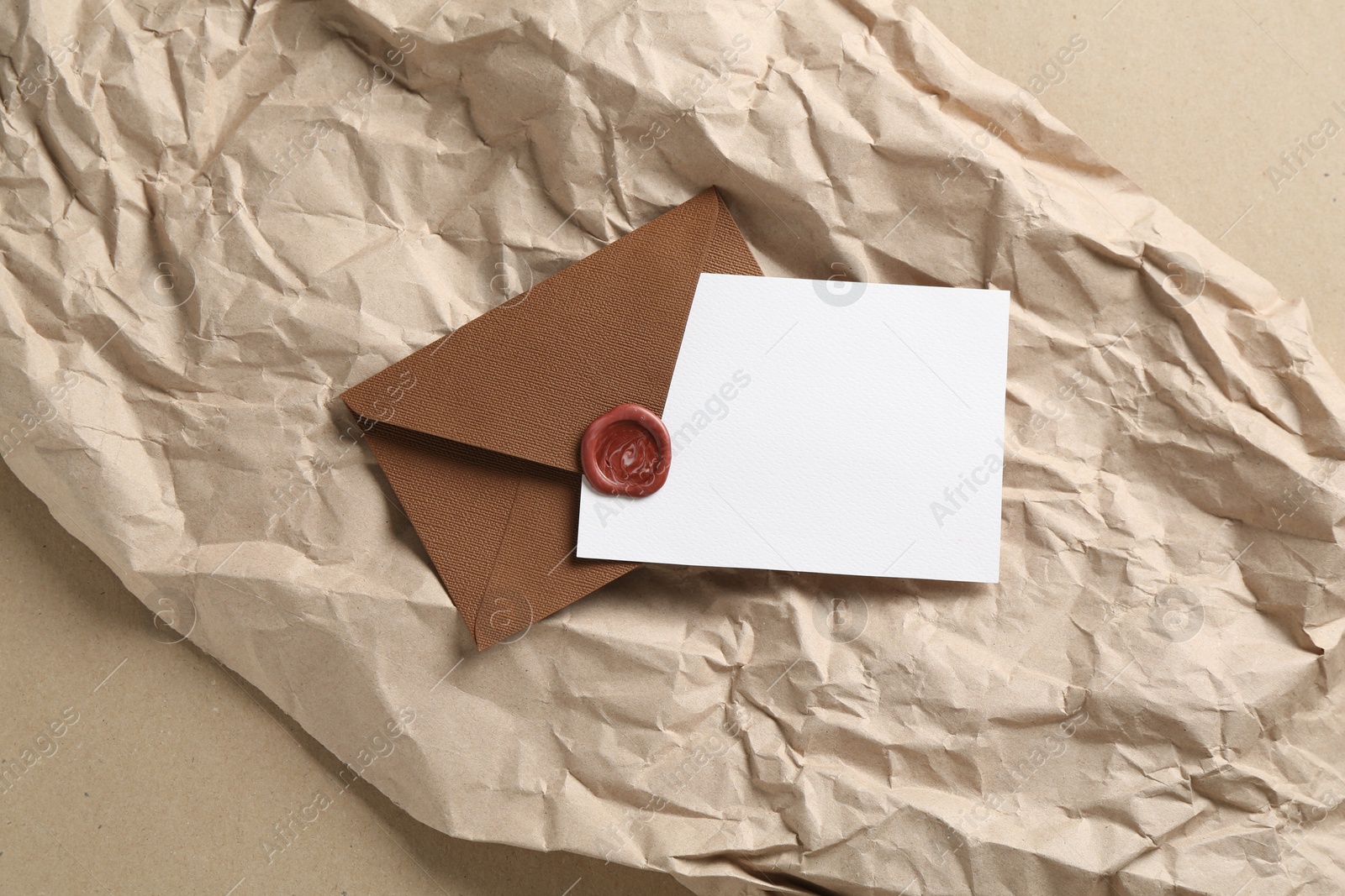 Blank invitation card, envelope and parchment paper on carton, top view. Space for design Photo of Blank invitation card, envelope and parchment paper on carton, top view. Space for design