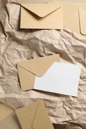Photo of Blank invitation card, envelopes and parchment paper on table, flat lay. Space for design