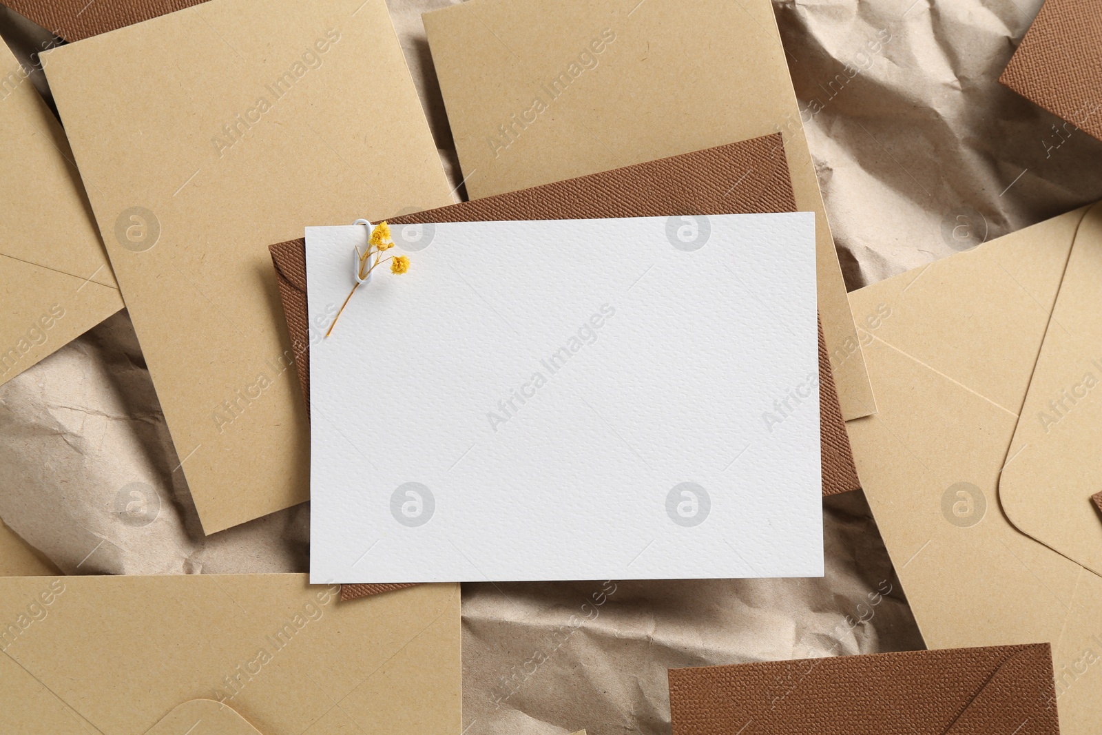 Blank invitation card with flowers and envelopes on parchment paper, flat lay. Space for design Photo of Blank invitation card with flowers and envelopes on parchment paper, flat lay. Space for design