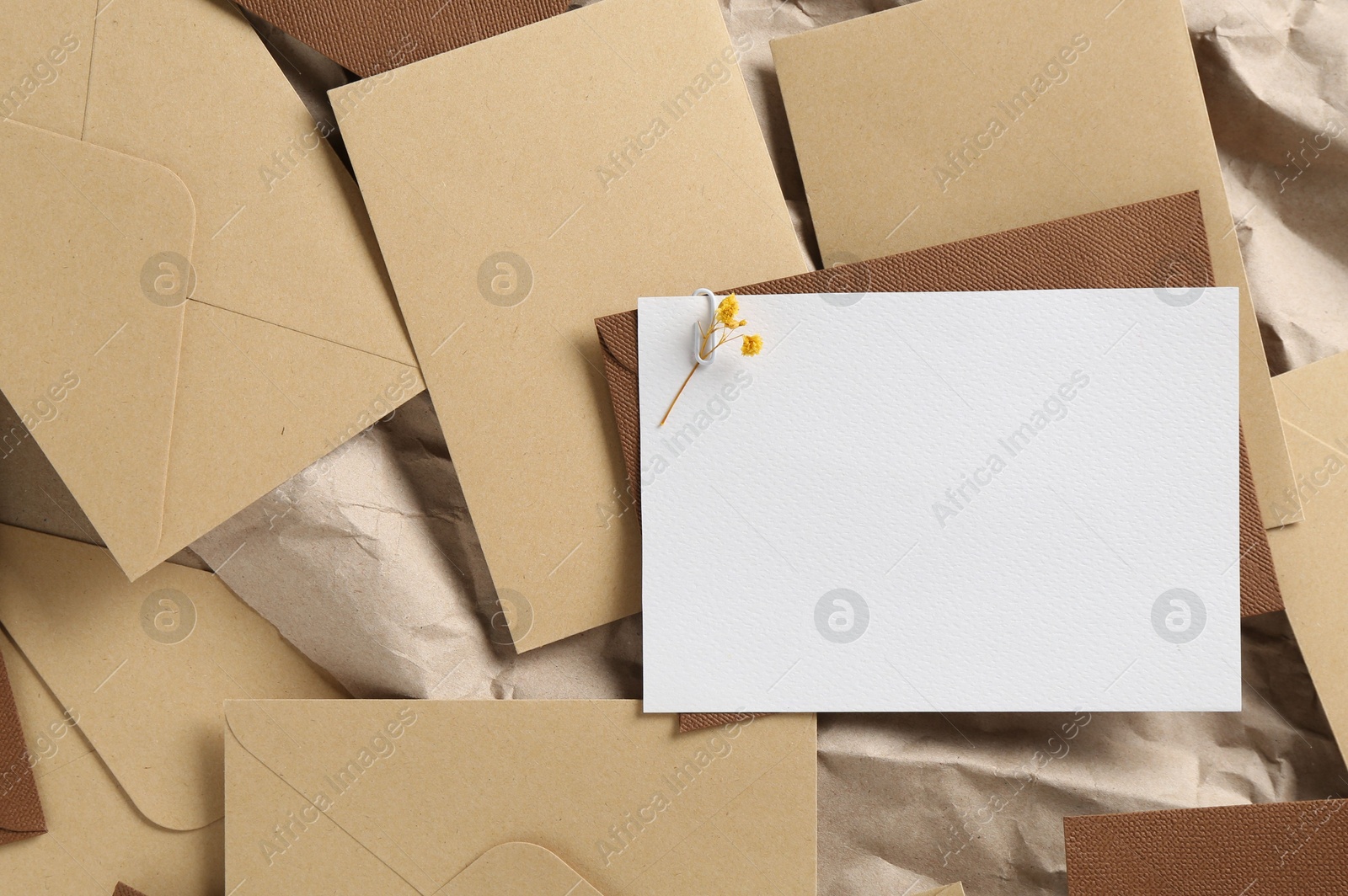 Blank invitation card with flowers and envelopes on parchment paper, flat lay. Space for design Photo of Blank invitation card with flowers and envelopes on parchment paper, flat lay. Space for design