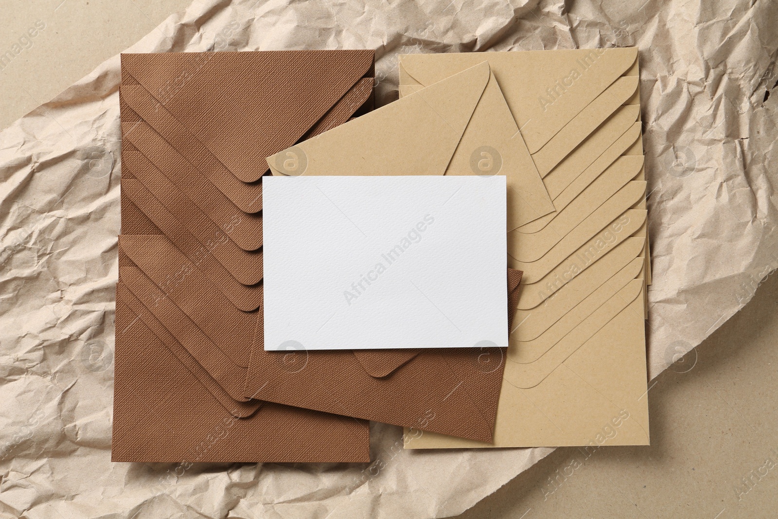 Blank invitation card, envelopes and parchment paper on carton, top view. Space for design Photo of Blank invitation card, envelopes and parchment paper on carton, top view. Space for design