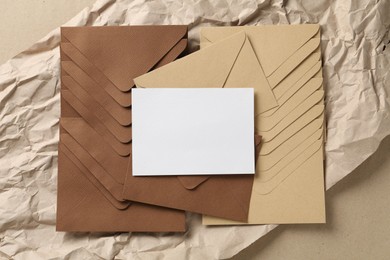 Photo of Blank invitation card, envelopes and parchment paper on carton, top view. Space for design