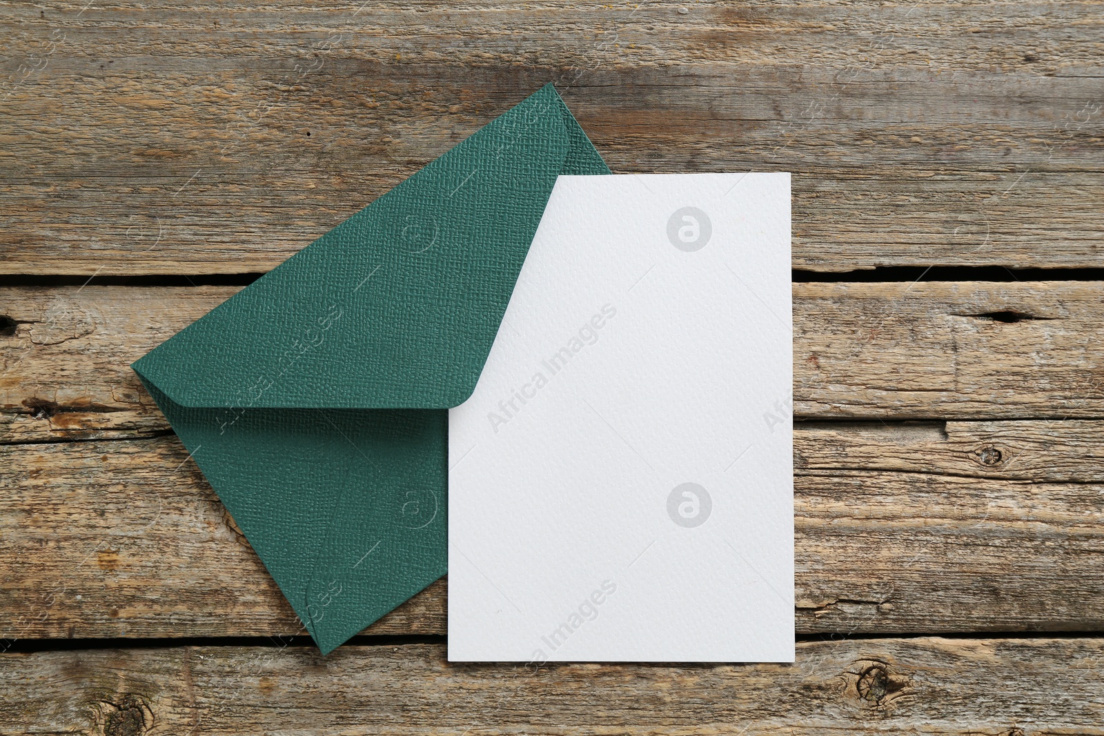 Blank invitation card and envelope on wooden table, top view. Space for design Photo of Blank invitation card and envelope on wooden table, top view. Space for design