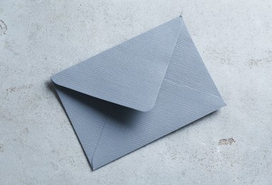 Photo of Beautiful invitation envelope on light grey table, top view