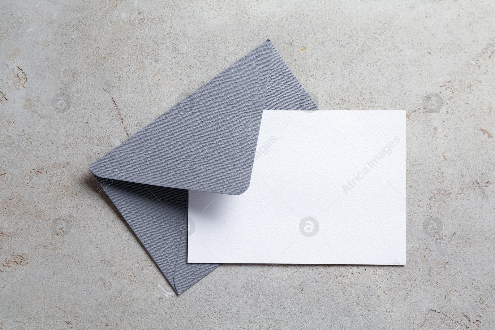 Blank invitation card and envelope on light grey table, top view. Space for design Photo of Blank invitation card and envelope on light grey table, top view. Space for design