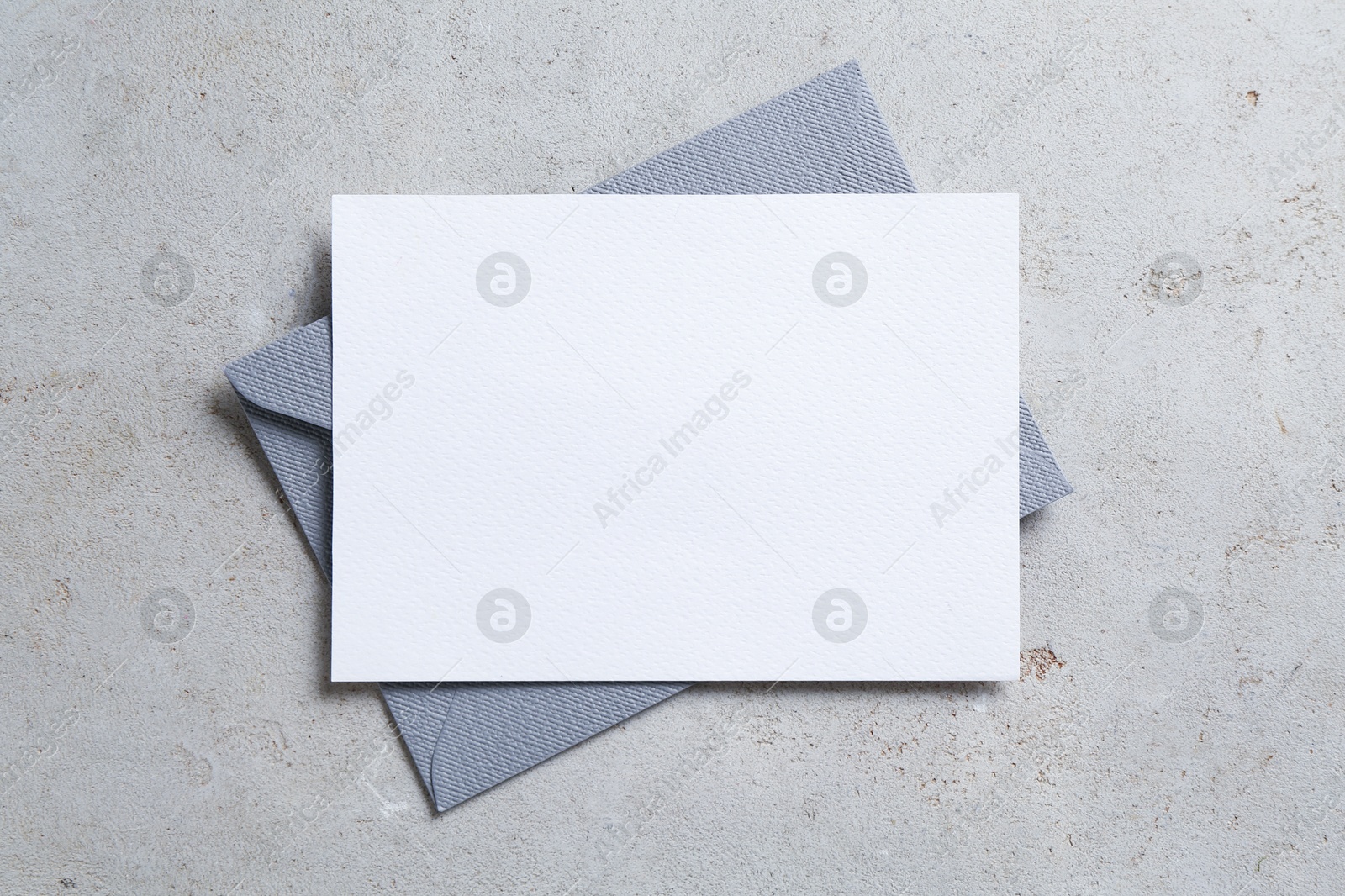 Blank invitation card and envelope on light grey table, top view. Space for design Photo of Blank invitation card and envelope on light grey table, top view. Space for design