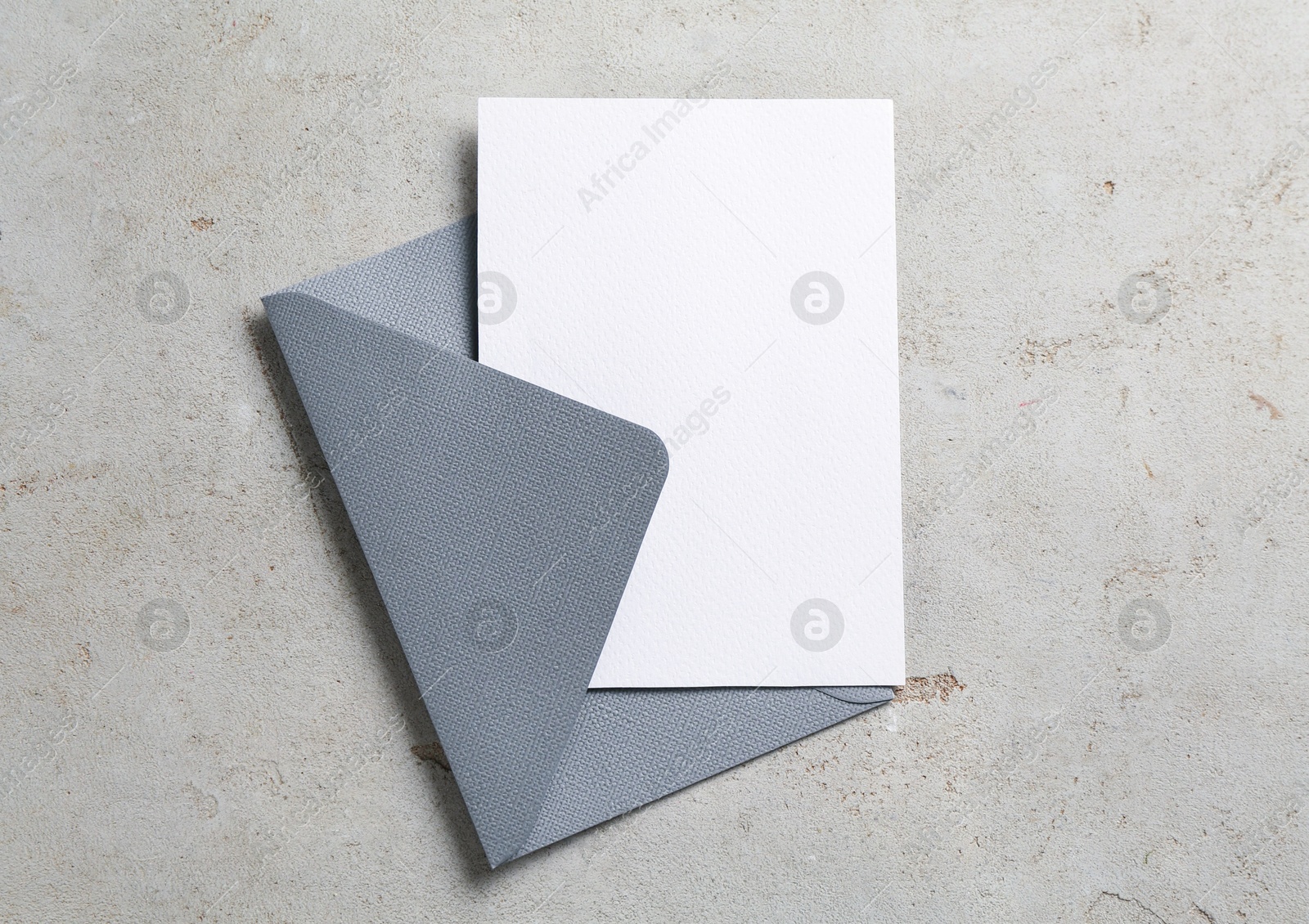 Blank invitation card and envelope on light grey table, top view. Space for design Photo of Blank invitation card and envelope on light grey table, top view. Space for design