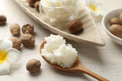 Photo of Natural shea butter on white wooden table, closeup