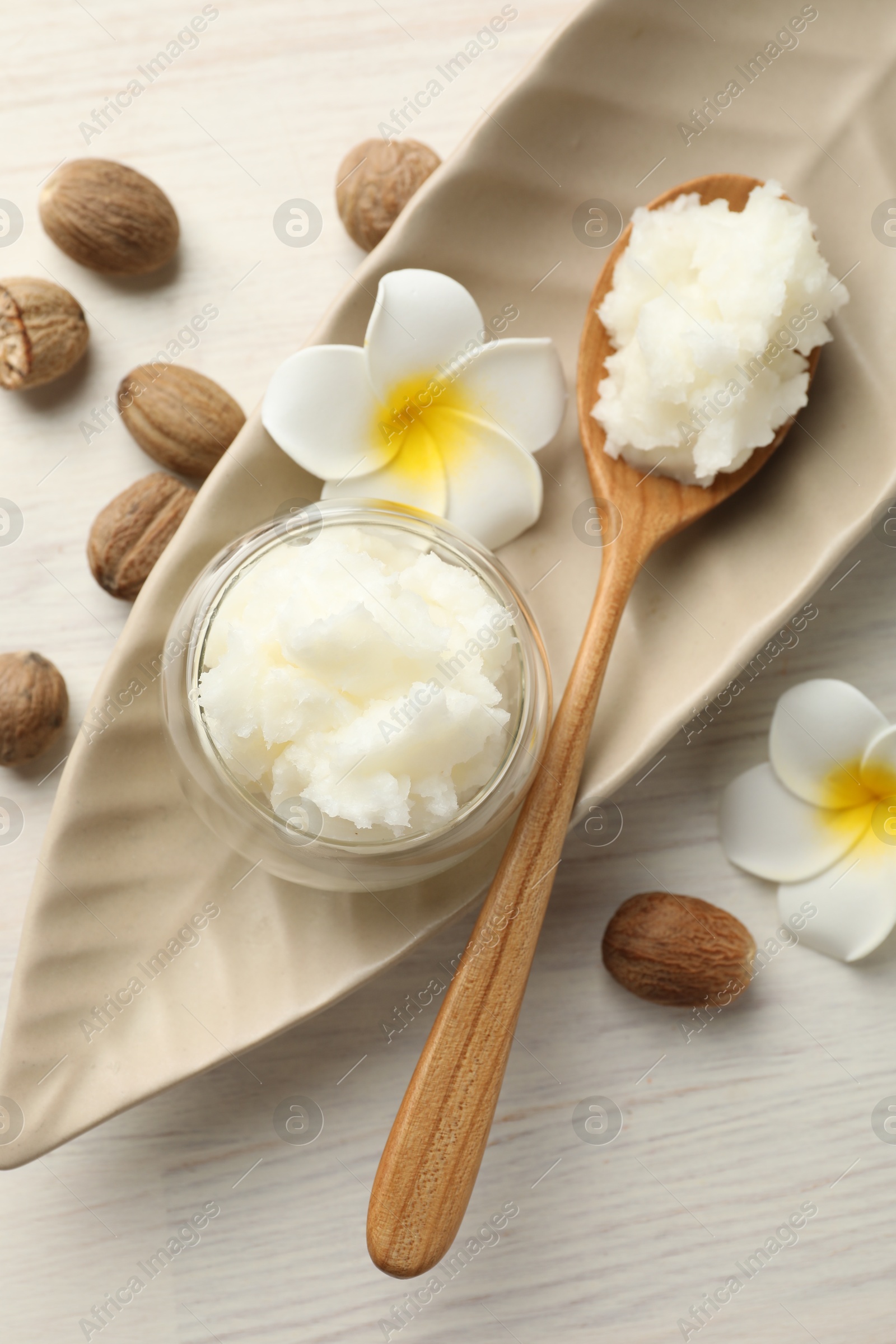 She butter, nuts and plumeria flowers on white wooden table, flat lay Photo of She butter, nuts and plumeria flowers on white wooden table, flat lay