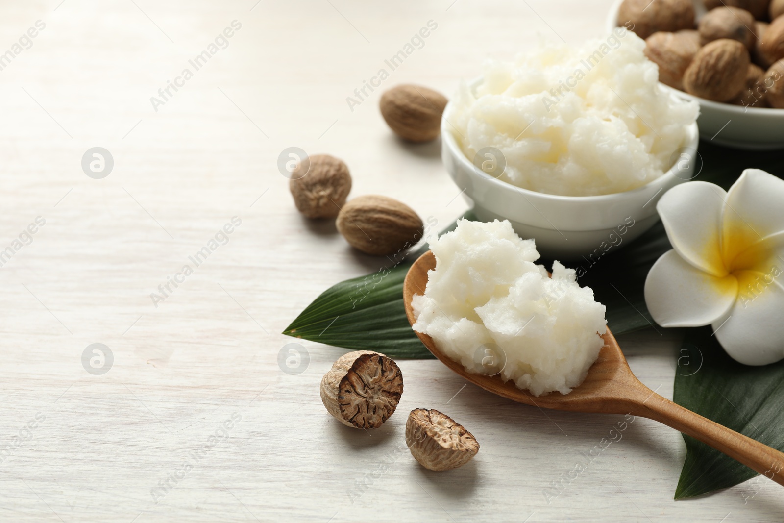 Photo of Natural shea butter on white wooden table, closeup. Space for text