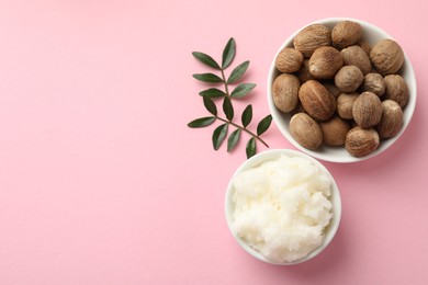 Photo of She butter, nuts and leaves on pink background, flat lay. Space for text