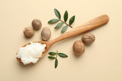 Photo of She butter, nuts and leaves on beige background, flat lay