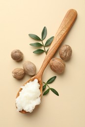 Photo of She butter, nuts and leaves on beige background, flat lay