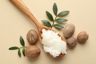 Photo of She butter, nuts and leaves on beige background, flat lay