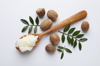 Photo of Shea butter, nuts and leaves on white background, flat lay