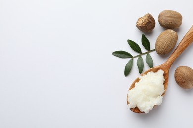 Photo of Shea butter, nuts and leaves on white background, flat lay. Space for text