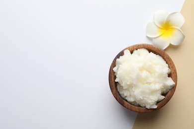 Photo of Shea butter and plumeria flower on color background, top view. Space for text