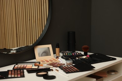 Photo of Different makeup products on dressing table indoors